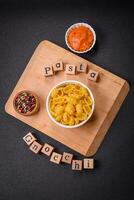 Raw durum wheat gnocchi pasta with salt and spices in a ceramic plate photo