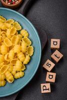 Raw durum wheat gnocchi pasta with salt and spices in a ceramic plate photo