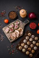 Raw quail eggs in a plastic box on a dark concrete background photo