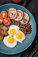 Delicious nutritious breakfast of fried quail eggs, bacon, legumes and cherry tomatoes photo