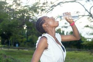 lady drinking a bottle of water after a long day of stress photo