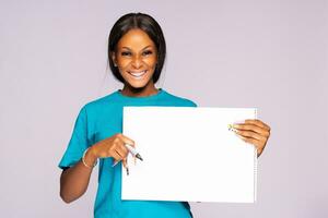 beautiful young black woman smiling while holding a blank pad photo