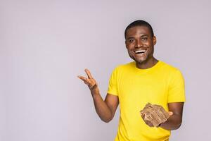 excited and happy young black man holding a lot of money photo