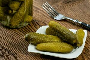 pepinos en escabeche en vinagre en un plato foto