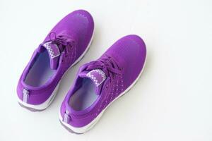 Pair of new purple sneakers. Fashionable and comfortable sport footwears. White background. Concept, shoes for doing sport or exercise, also can wear for traveling, hiking. photo