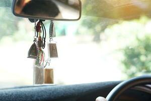 Closeup Buddha amulets hang in front console of the car. Concept, faith and belief for Buddhist for holy and luck. Prevention from accident. photo