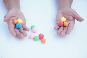 Close up man hands holds small colorful plasticine dough balls. Concept, alzheimer, weak muscle patients recovering activity by sculpting. Make concentration. Develop imagination. photo