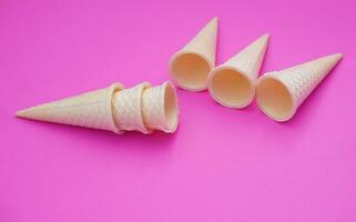 Empty crispy waffle ice cream cones isolated on pink background. Concept, part of pattern of ice creams in cone shape. Snack and dessert. copy space for text. photo