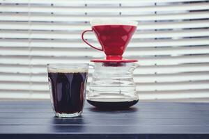 Pouring coffee into a glass on the table photo