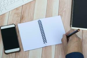 Businessman hands with pen writing notebook on office desk table. photo