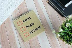 Flat lay of notepad with text goal, plan, action. photo