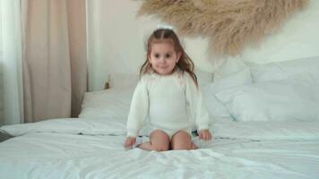 vrolijk gelukkig meisje 2 jaren oud jumping Aan de bed. video