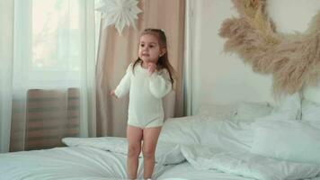 glad Lycklig flicka 2 år gammal Hoppar på de säng. video