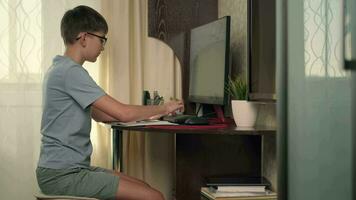 Boy writes program code at home using computer video