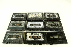 a group of nine cassette tapes on a white surface photo