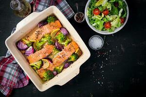 Baked salmon fillet with broccoli, red onion and lemon. Top view, overhead photo