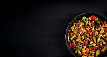 Stir fry with chicken, mushrooms, broccoli and peppers. Chinese food. Top view, overhead photo