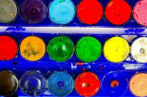 a blue paint tray with many different colored paints photo