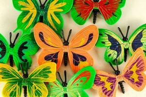 a group of colorful butterflies are arranged on a white surface photo