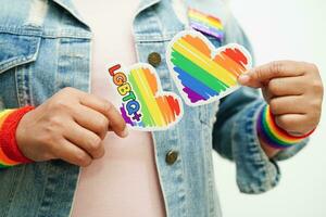 Asian woman with rainbow flag, LGBT symbol rights and gender equality, LGBT Pride Month in June. photo