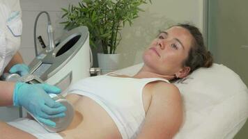 Mature woman enjoying endospheres hardware massage at beauty clinic video