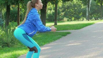 Athletic fit woman doing squats outdoors in the morning video