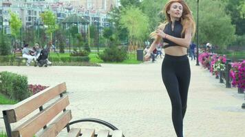 Gorgeous fit woman resting on the bench after jogging video