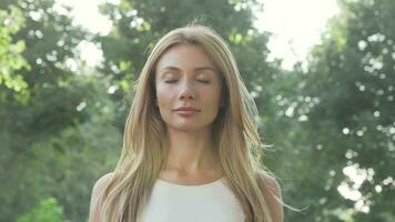 Beautiful happy woman enjoying relaxing outdoors in the park in summer evening video