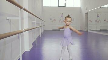 linda pequeño bailarina en leotardo girando en danza a ballet colegio video