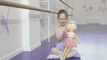 voll Länge Schuss von ein schön wenig Ballerina winken zu das Kamera spielen mit ein Puppe video