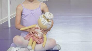 süß glücklich wenig Ballerina Mädchen lächelnd freudig halten Ballerina Puppe video