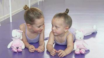 Two little ballerinas lying on the floor at ballet school resting after practicing video