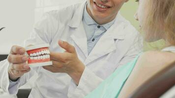 masculino dentista segurando dental mofo explicando dentes Cuidado para paciente video