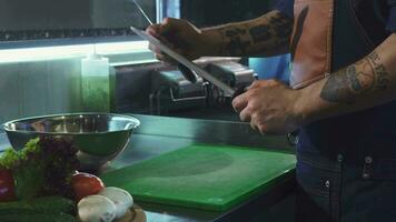 Cropped shot of a professional chef sharpening his knife video