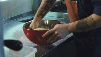 Male chef preparing dough working at the kitchen video