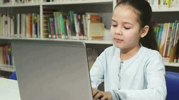 bonito pequeño asiático niña estudiando trabajando en su ordenador portátil video