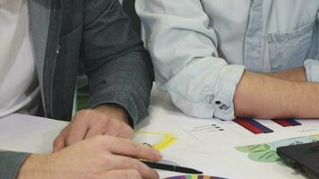 Close up of two business colleagues talking examining documents video