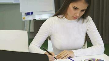 ritagliata tiro di un' giovane attività commerciale donna scrittura Appunti a il ufficio video