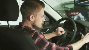 Attractive bearded man smiling to the camera over his shoulder sitting in a new car video