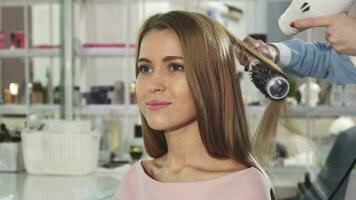 Young gorgeous woman getting her hair dryed by a professional hairstylist video