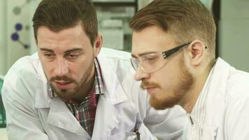 de cerca de el caras de el laboratorio técnicos quien conducta un grave conversacion video