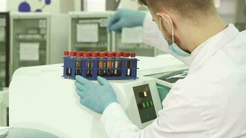 A professional lab technician checks each of the tubes before loading them into a laboratory centfruge video