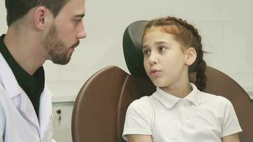 un triste niña describe su dolor de muelas a el médico video