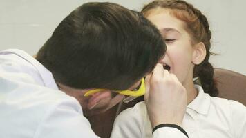 An attentive dentist examines his small patient video