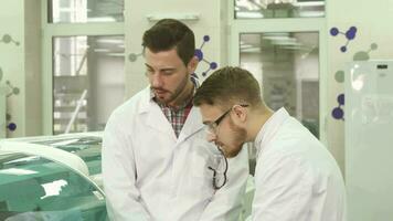 deux Jeune laboratoire assistants discuter le nuances de leur flux de travail video