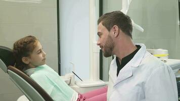 Lovely dentist talking with his young patient video