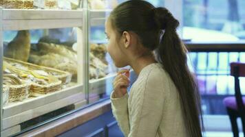 süß wenig Mädchen suchen beim das Anzeige beim das lokal Bäckerei video