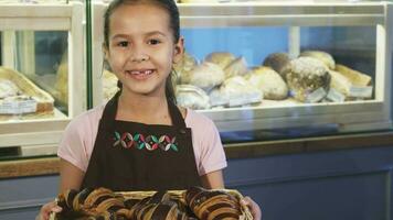 adorabile poco ragazza indossare grembiule Lavorando a il forno sorridente per il telecamera video