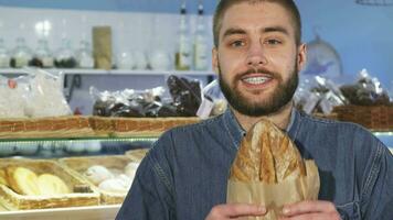 dichtbij omhoog van een vrolijk Mens ruiken vers gebakken brood video