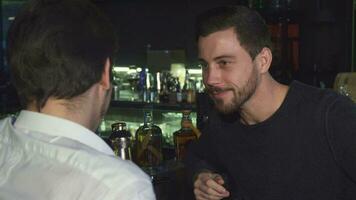 ung manlig vänner talande medan har drycker tillsammans på de bar video